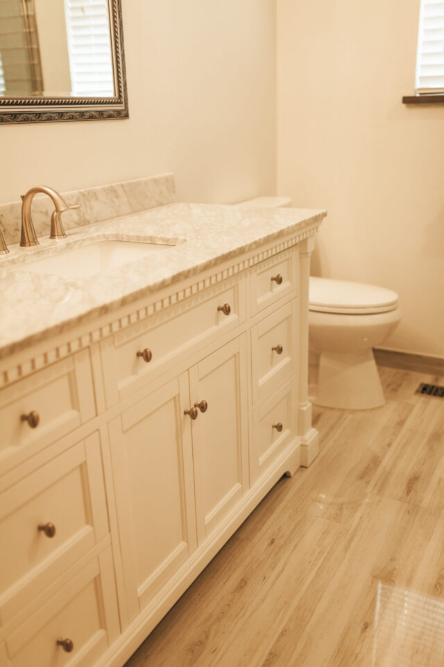 bathroom remodel with a single sink vanity and wood floors