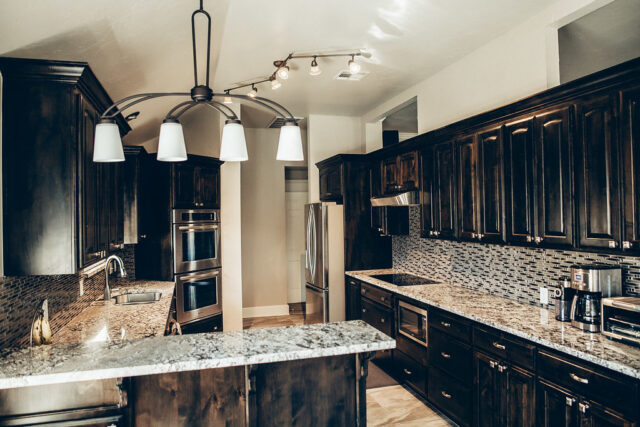 dark wooden cabinets and granite cabinet tops in a kitchen remodeling project