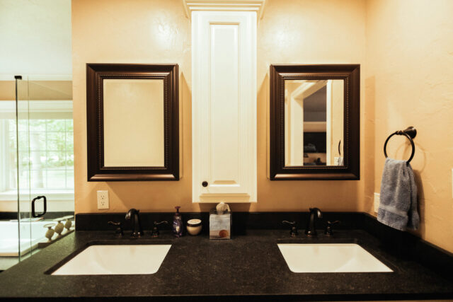 bathroom remodel with a double vanity that includes two sinks and two framed mirrors